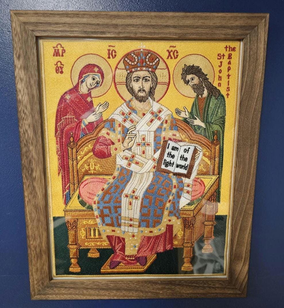 Embroidered icon of Christ enthroned, flanked by Mary and John, in wooden frame
