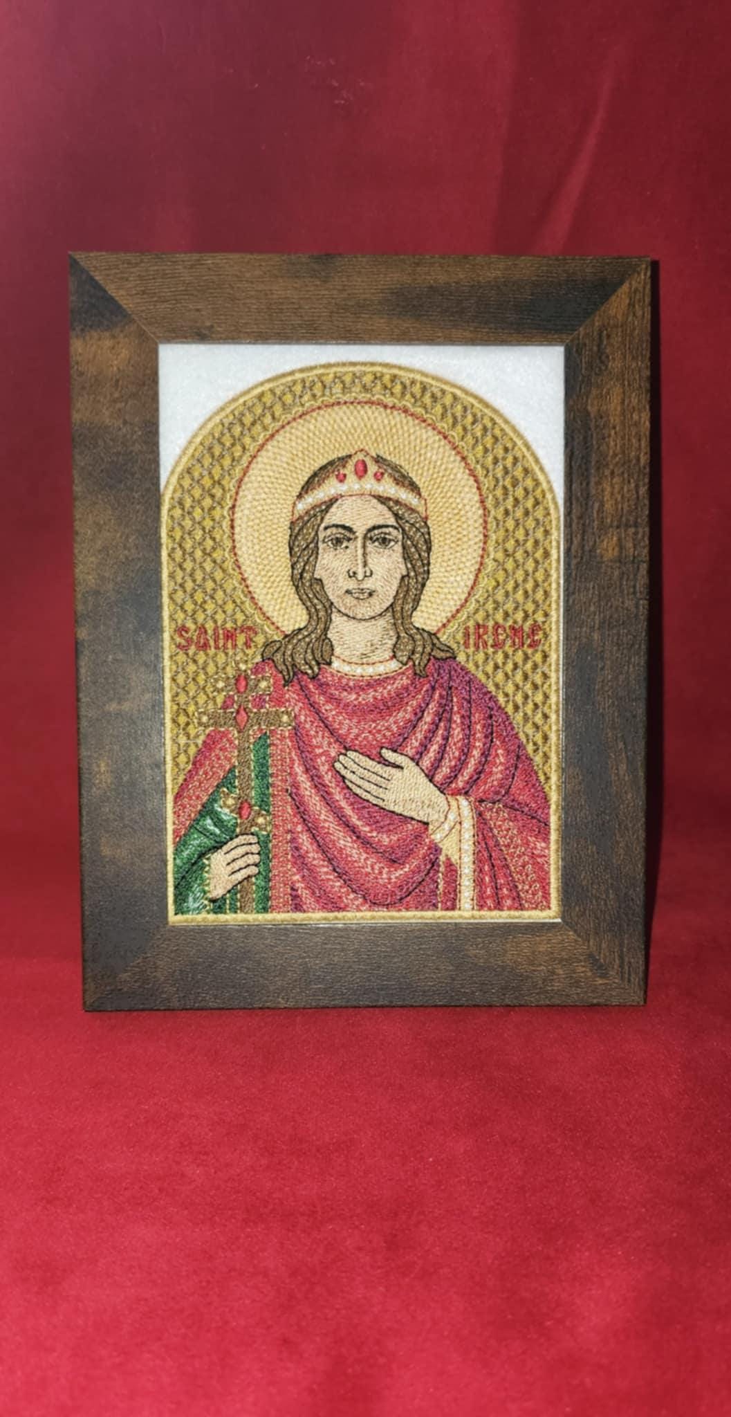 Framed embroidery of Saint Irene holding a jeweled cross with golden halo on red background
